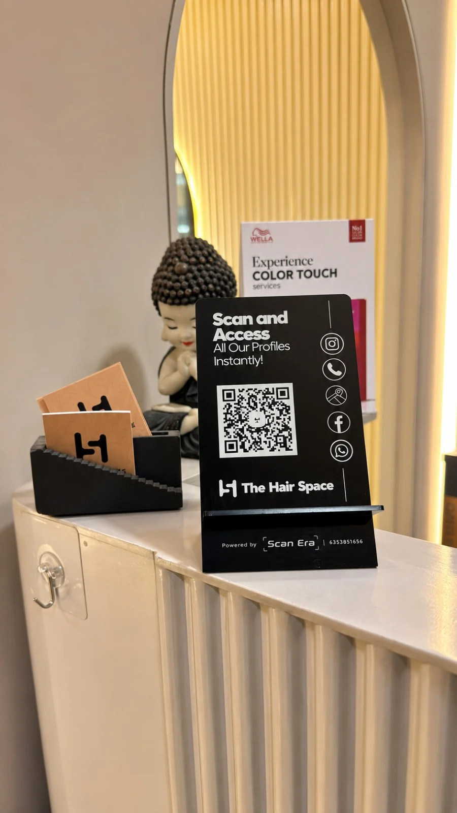 Black ScanEra business QR standee customised for The Hair Space, photographed on a salon counter